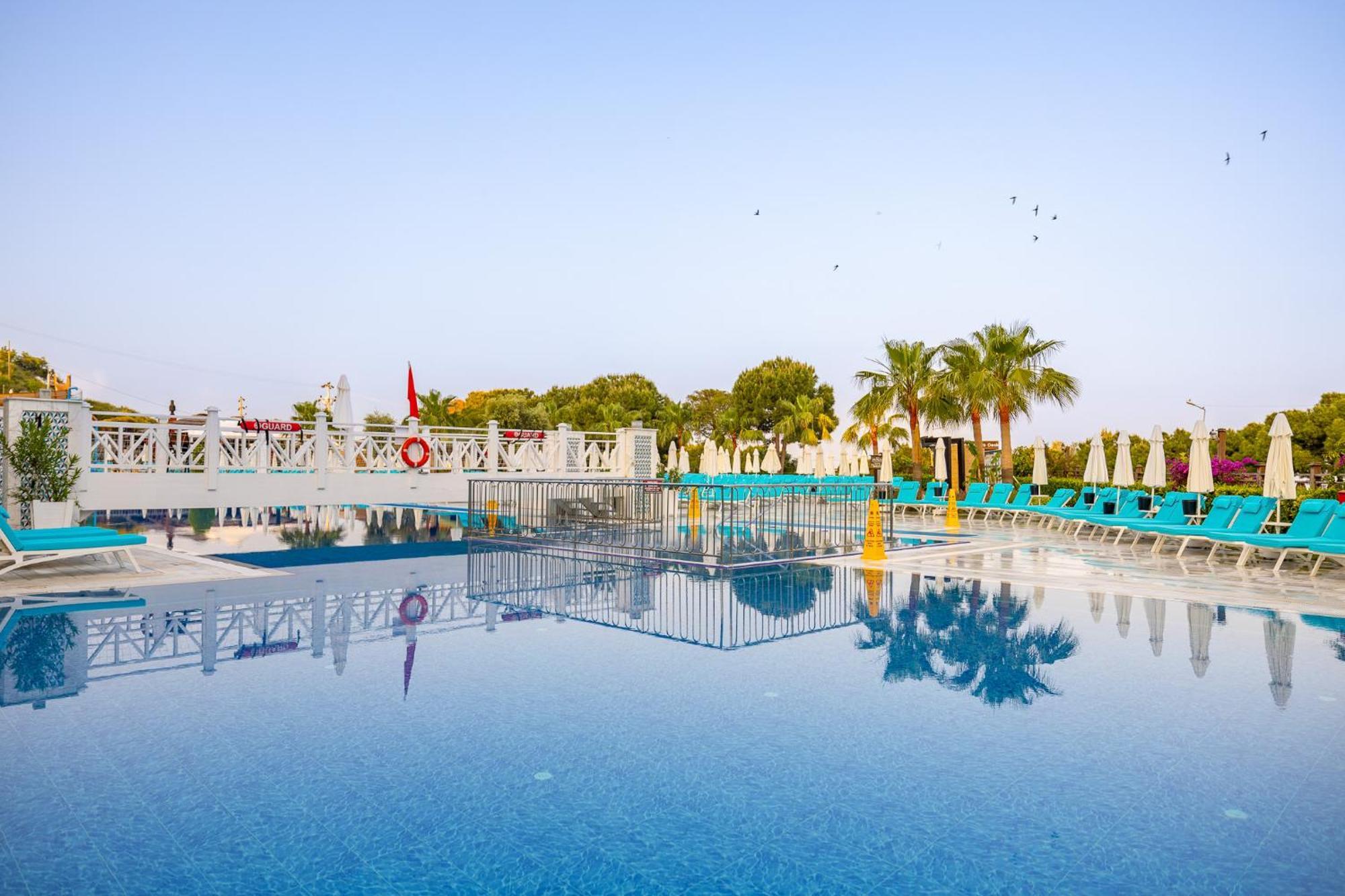 Ramada Resort Kusadasi & Golf Exterior photo A swimming pool at a hotel in Turkey