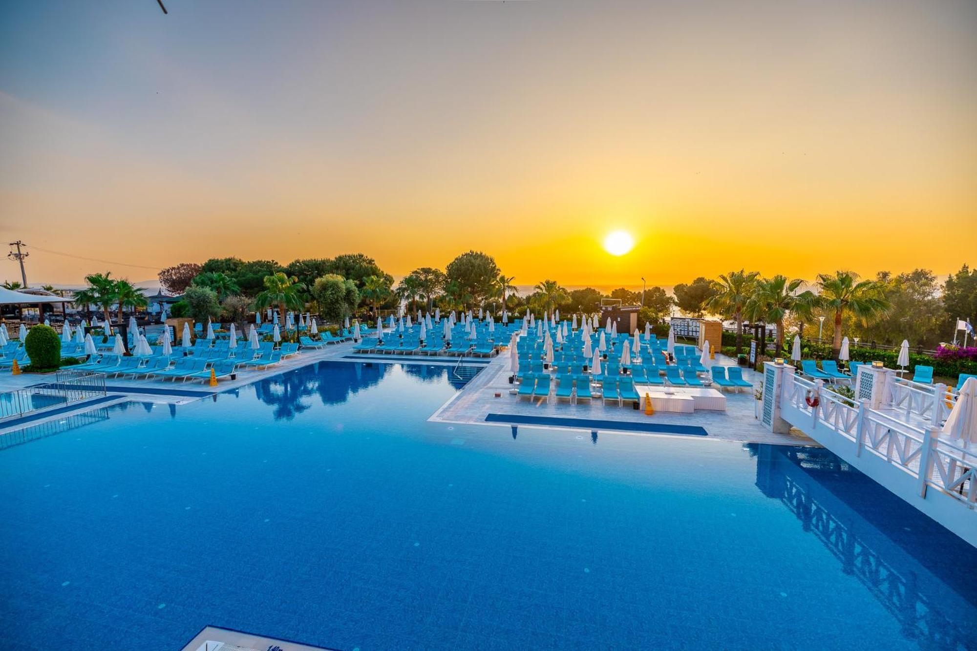 Ramada Resort Kusadasi & Golf Exterior photo Sunset at the pool of the hotel